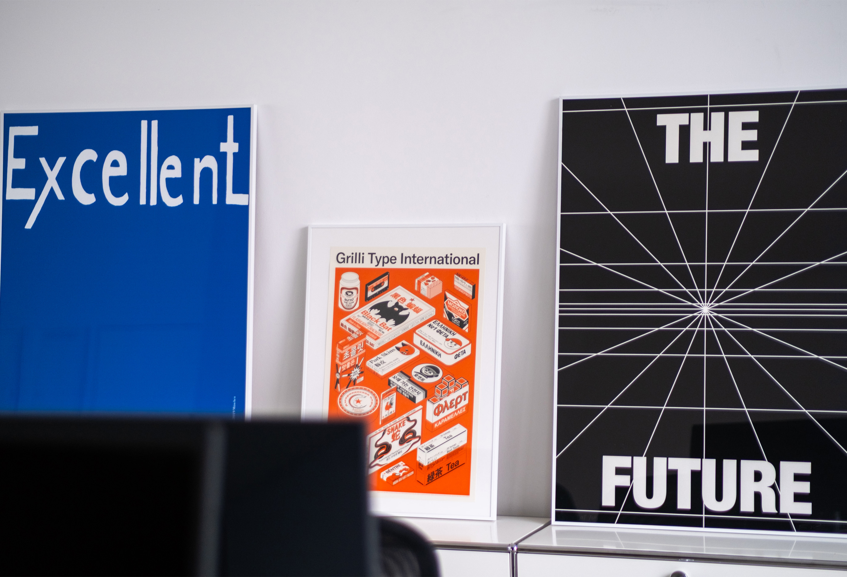 Three graphic posters leaning on a studio surface