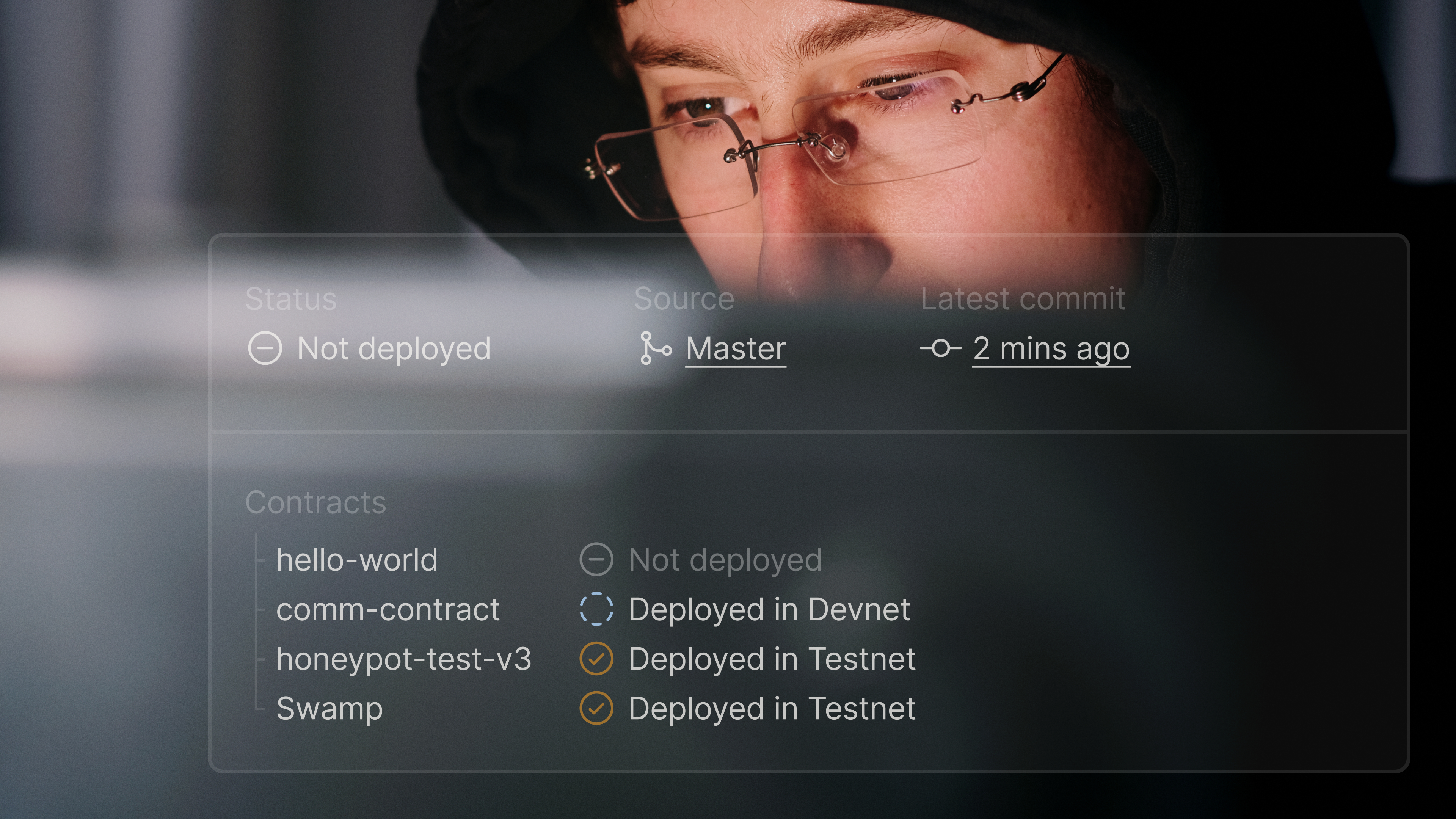 Developer looking at a monitor through dark-rimmed glasses with a Hiro contract deployment status panel overlaid